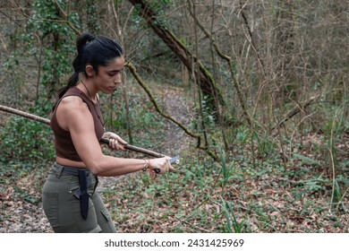 A young explorer sharpens a stick with her survival knife amidst the wild, honing her outdoor expertise. - Powered by Shutterstock