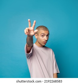 Young Expressive Emotional Man Showing Three Fingers Gesture On Blue Background