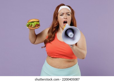 Young Expressive Sad Chubby Overweight Plus Size Fat Fit Woman Wear Red Top Warm Up Training Hold Fast Food Burger Scream Shout In Megaphone Isolated On Purple Background Gym. Workout Sport Concept.