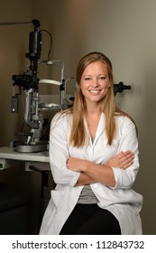 Young Eye Doctor In Her Office With Equipment On The Background