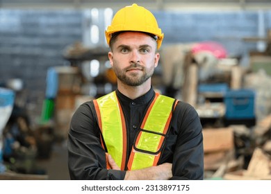 Young factory worker in hard hat sdaning at industry site - Powered by Shutterstock