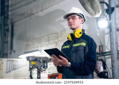 Young factory worker using adept tablet computer in a workshop building . Industrial technology and manufacturing software configuration . - Powered by Shutterstock