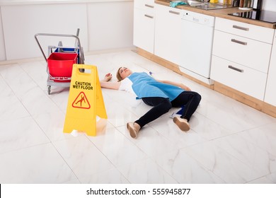 Young Fainted Housemaid Lying On Floor In Kitchen. Accident Compensation Concept