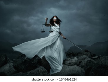 Young fairly woman with scale and sword over dramatic sky with copy space