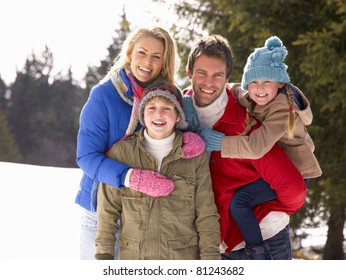 Young Family  In Alpine Snow Scene