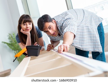 Young Family Assembling Furniture At New House