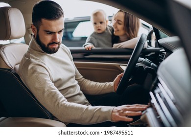 Young Family With Baby Girl Choosing A Car