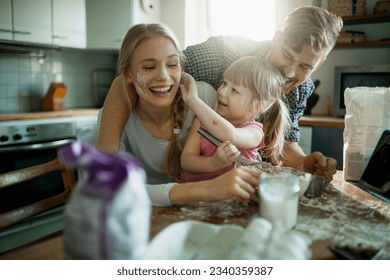 Young family baking a cake together in the kitchen - Powered by Shutterstock