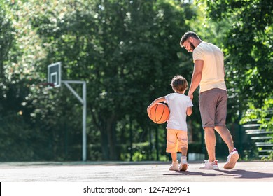 Young Family With A Ball On The Basketball Court