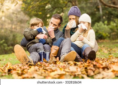 Young family blowing their nose on an autumns day - Powered by Shutterstock