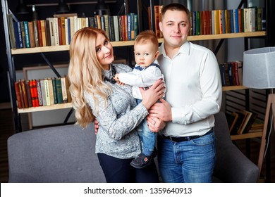 Young family with a boy in the apartment. Pama and mom play with a small child at home. Happy parents with son - Shutterstock ID 1359640913