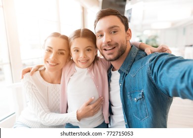 A young family came together in a cafe. Mom, dad and little daughter drink tea, eat cakes. They are happy together. Happy family lunch concept. Family selfie concept. - Powered by Shutterstock