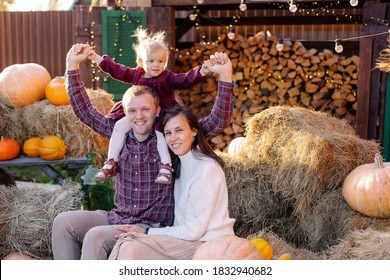 A Young Family Celebrates Thanksgiving Outside. Happy Parents And Child In Country Side Harvest. Hello, Autumn! Festive Mood. Preparing For Halloween. Pumpkin Decor. Togetherness Together. Positive