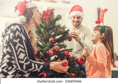 Young Family Celebrating Christmas At Home.Happy Young Family Enjoying Their Holiday Time Together.