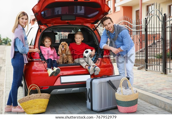 Young family with
children and dog near car