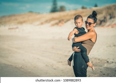 Young family with children playing on beautiful sunny sandy beach in New Zealand .