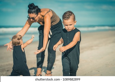 Young family with children playing on beautiful sunny sandy beach in New Zealand .