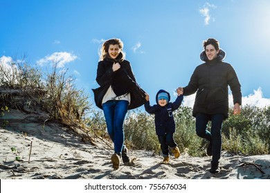 A Young Family With Children Spends The Weekend On The Shores Of The Cold Baltic Sea, Sandy Beach, Warm Jackets, Family Weekend With A Small Child