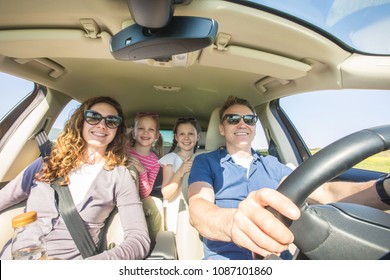 Young Family With Children Is Traveling In A Car On A Journey. View Inside The Machine