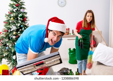 Young Family Cleaning Apartment After Christmas Party