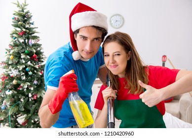 Young Family Cleaning Apartment After Christmas Party