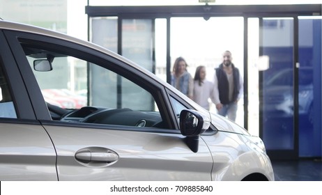 Young Family Comes Into Car Dealership To Choose The Car To Buy It.