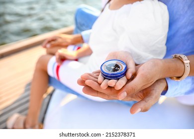 Young Family With Compass Resting On Yacht