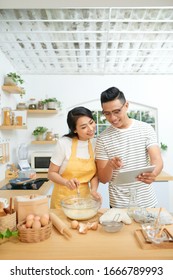 Young Family Cooking At Home, Using Digital Tablet. Mockup For Recipe