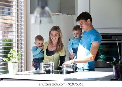 Young Family Cooking In A Modern Kitchen Setting