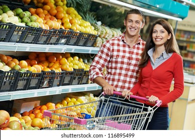 Young Family couple choosing bio food fruit in vegetable supermarket during weekly shopping - Powered by Shutterstock