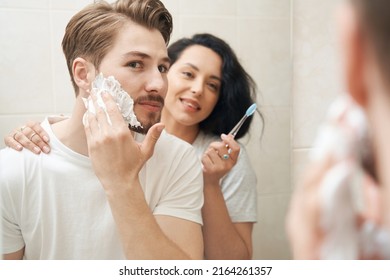 Young family couple standing before bathroom mirror - Powered by Shutterstock