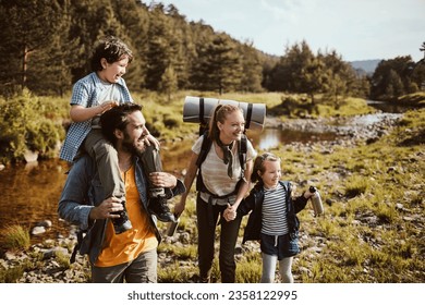 Young family crossing a creek while hiking in the forest and mountains - Powered by Shutterstock