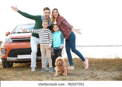 Young Family With Cute Children And Dog Near Car