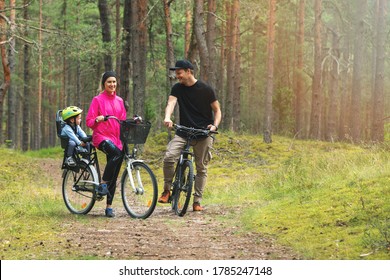 Young Family Cycling On Forest Trail With Kid In Bike Child Seat. Active Sports Outdoor Recreation