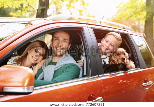 Young family with dog in\
car