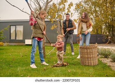 Young Family Doing The Autumn Yard Cleanup