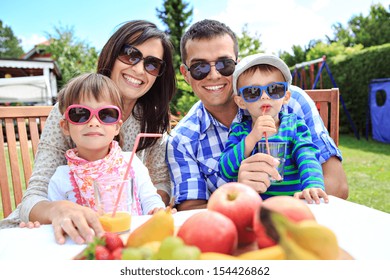 Young Family Eating In The Garden