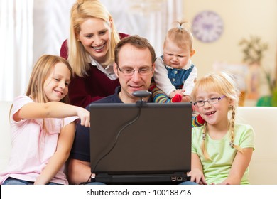 Young Family In Front Of Computer With Camera Having A Video Chat