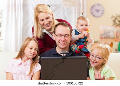 Young Family In Front Of Computer With Camera Having A Video Chat