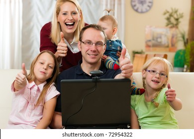 Young Family In Front Of Computer With Camera Having A Video Chat