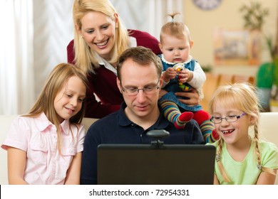 Young Family In Front Of Computer With Camera Having A Video Chat