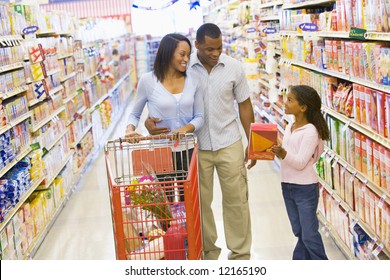 Young Family Grocery Shopping In Supermarket