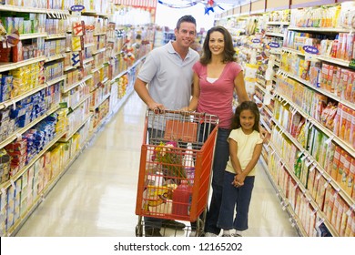 Young Family Grocery Shopping In Supermarket