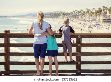 Young Family Hanging Out On An Ocean Pier On Vacation In Southern California