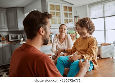 Young family having breakfast together and being messy in the kitchen - Powered by Shutterstock