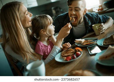 Young family having breakfast together in the morning in the kitchen at home - Powered by Shutterstock