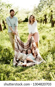 Young Family  Having Fun In Apple Orchard