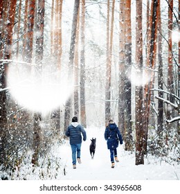 Young Family Having Fun With A Dog In Winter Forest On Vacations. Copy Space For Text. Selective Focus. 