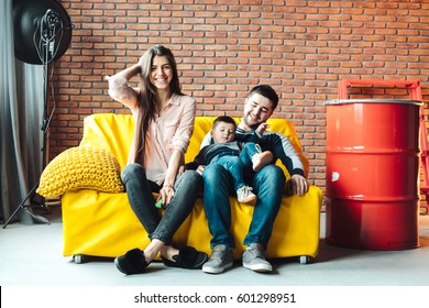 Young Family Having Fun On The Big Yellow Couch