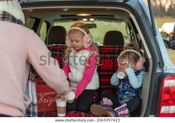 Young family having hot chocolate after a day at the\
Christmas tree farm